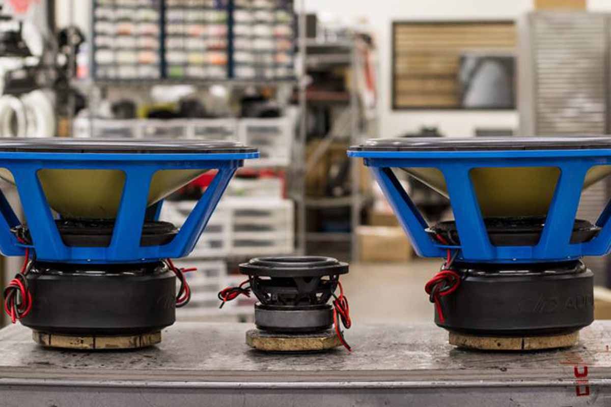 Two Large USA Made Subwoofers with electric blue powder coat baskets with a small USA Made subwoofer in between