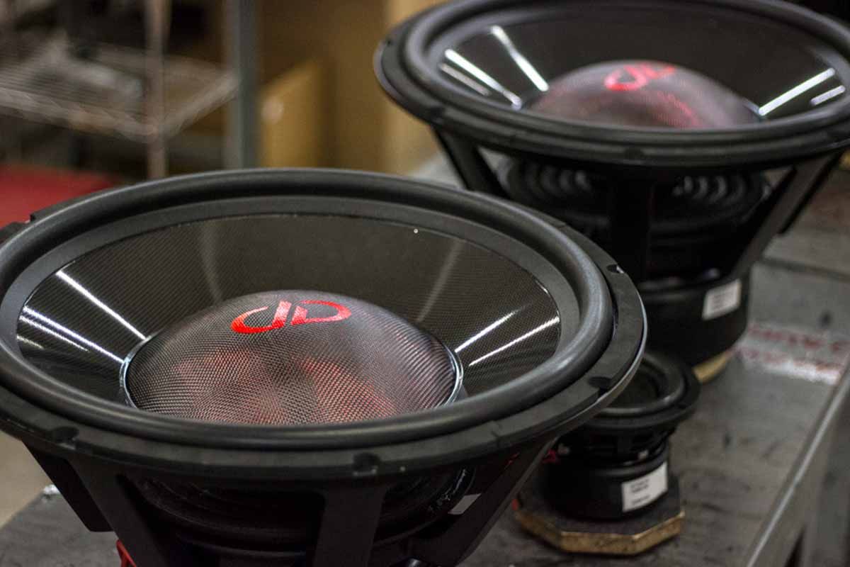 Two USA Made Subwoofers with polychromatic carbon fiber dust caps, high gloss black carbon fiber cones, and red DDA logos