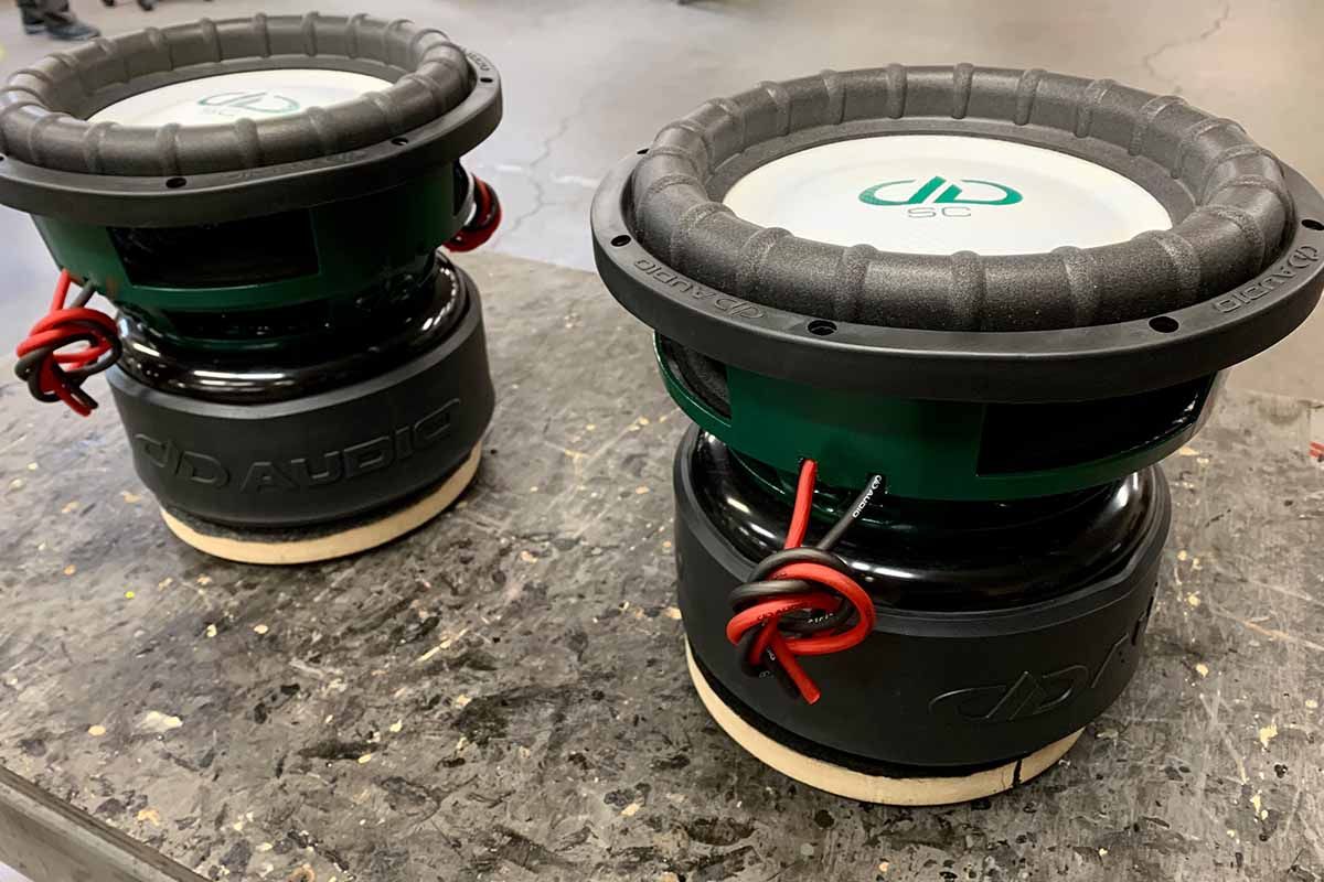 USA Made Subwoofers with green powder coat baskets, white cones, white dust caps and green DDA logos and Super Charged decals