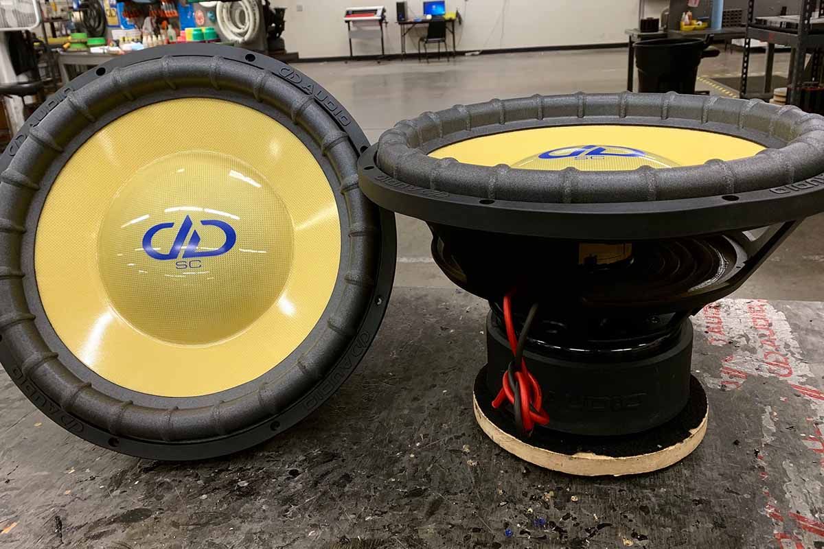 Two USA Made Subwoofers with yellow cone and high gloss dust cap with blue DDA Logo and super charged decal