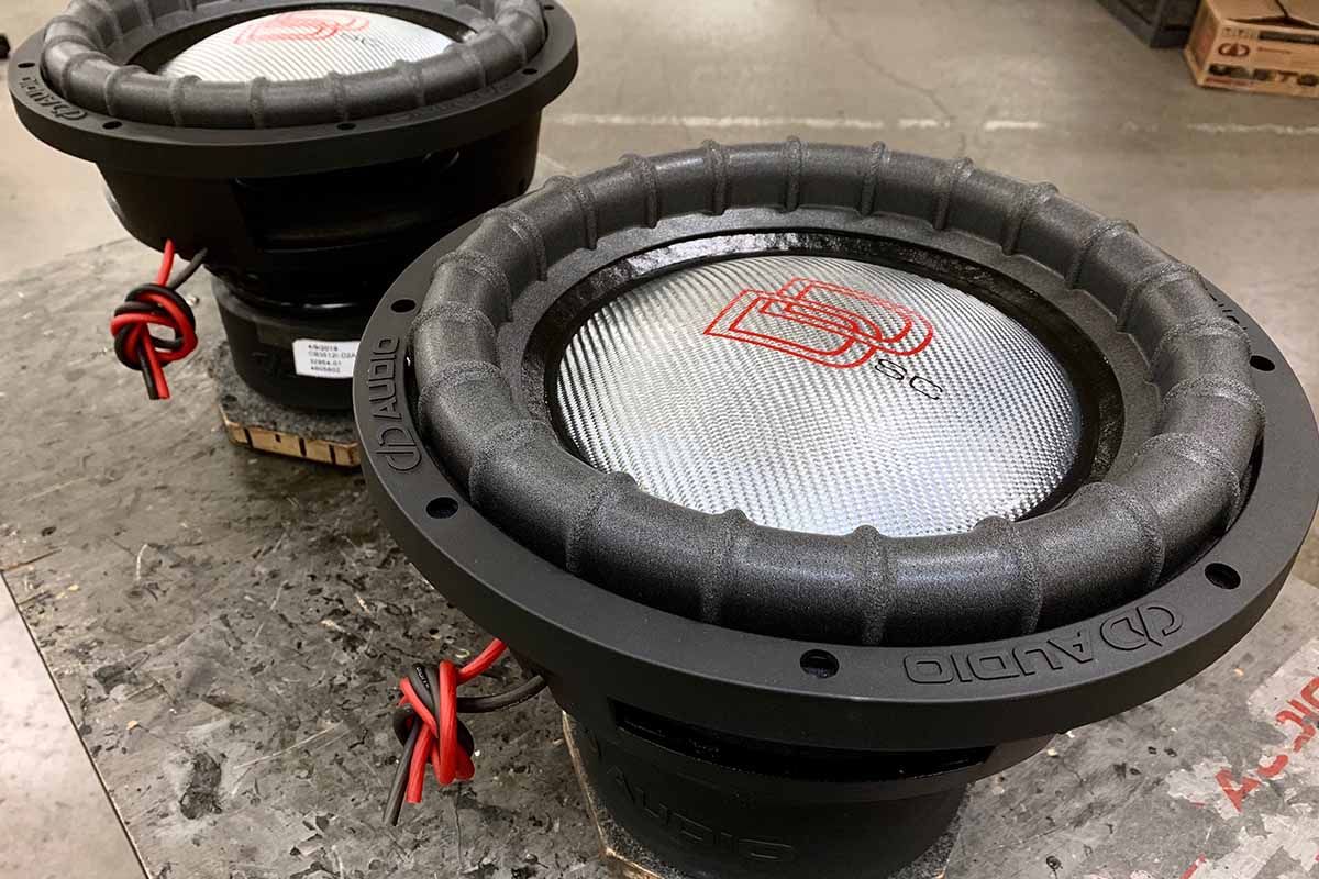 Two USA Made subwoofers with silver carbon fiber dust caps, red DD classic logos and black super charged decals