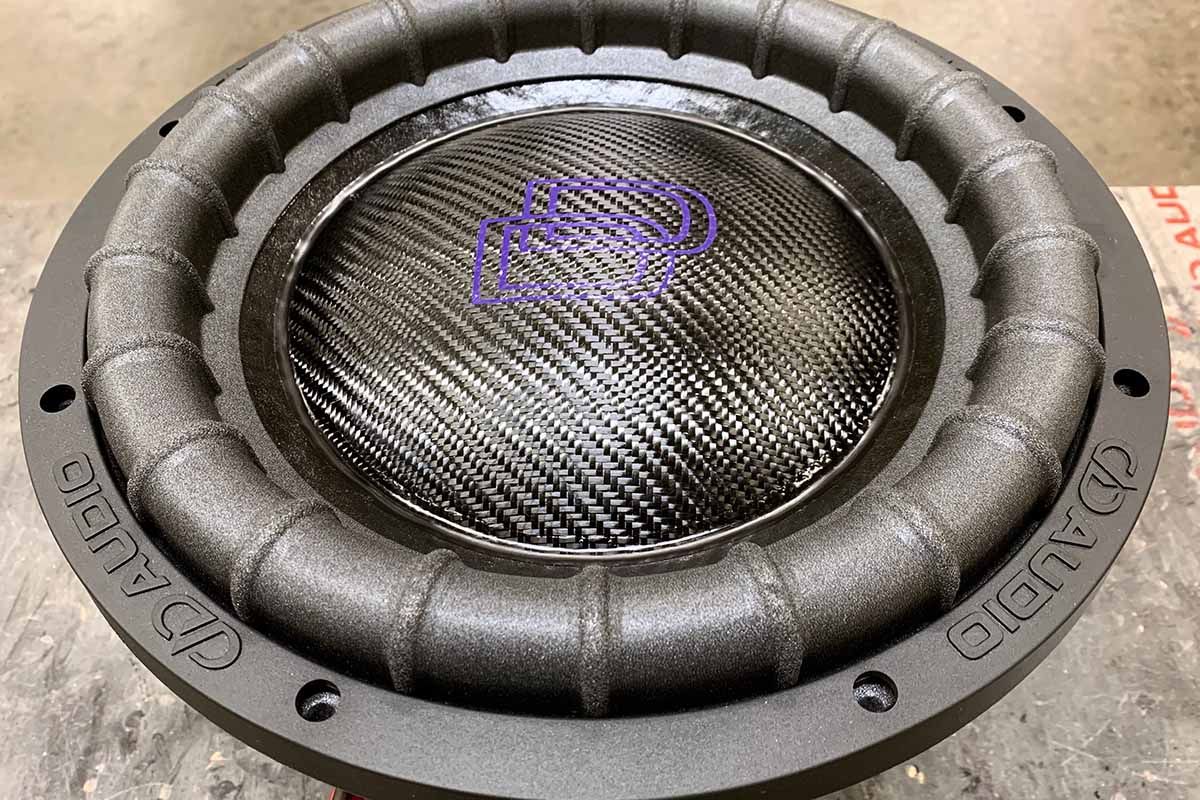 USA Made subwoofer with black carbon fiber dust cap on black cone with purple DD classic logo