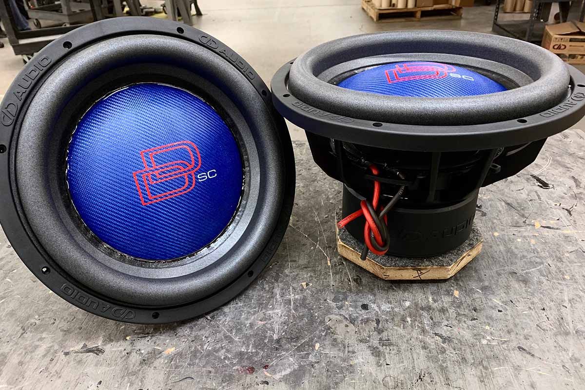 Two USA Made subwoofers with electric blue dust caps, red DD classic logos and white super charged decals