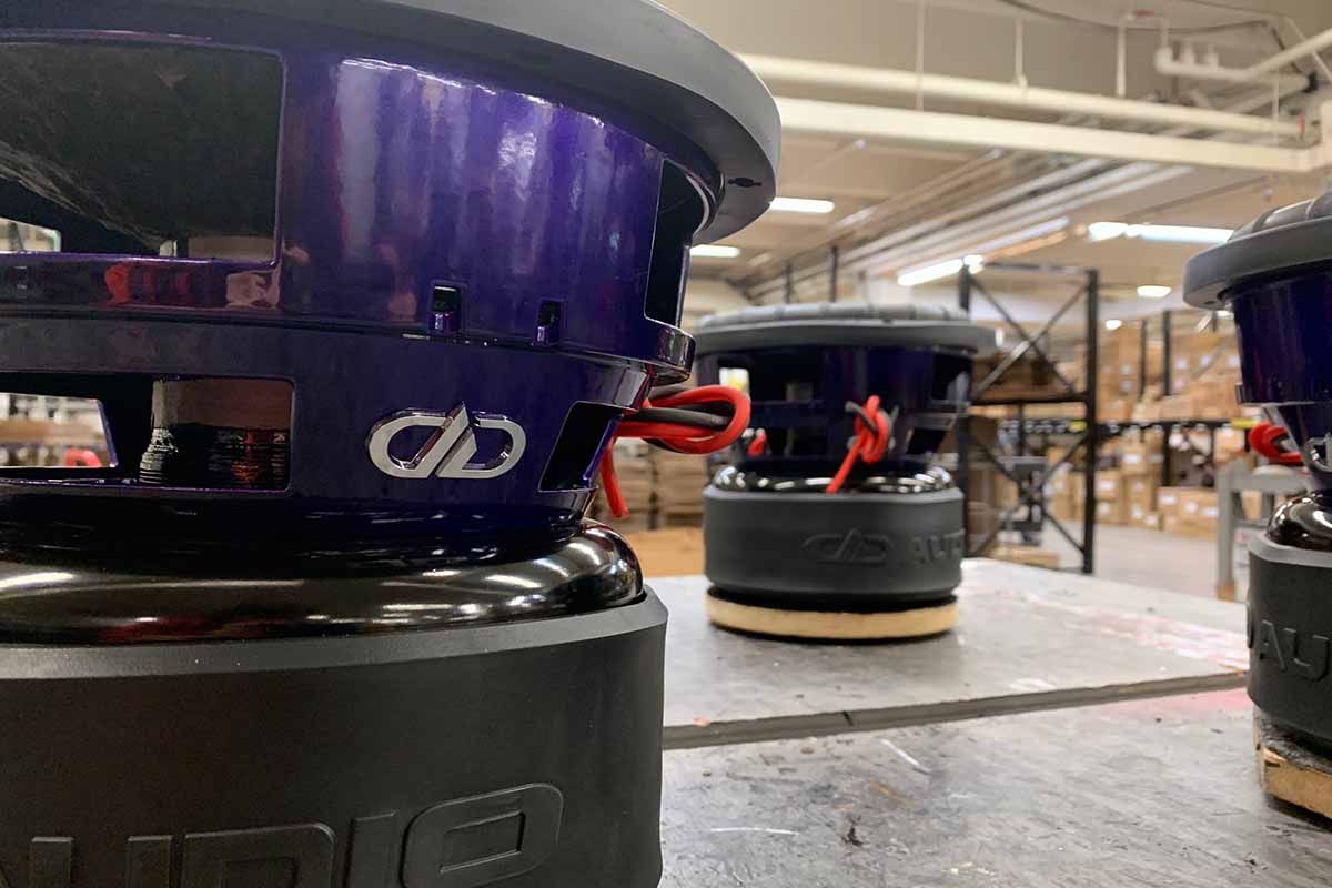 Three USA Made subwoofers with purple powder coat baskets and polished chrome DDA embossed logos