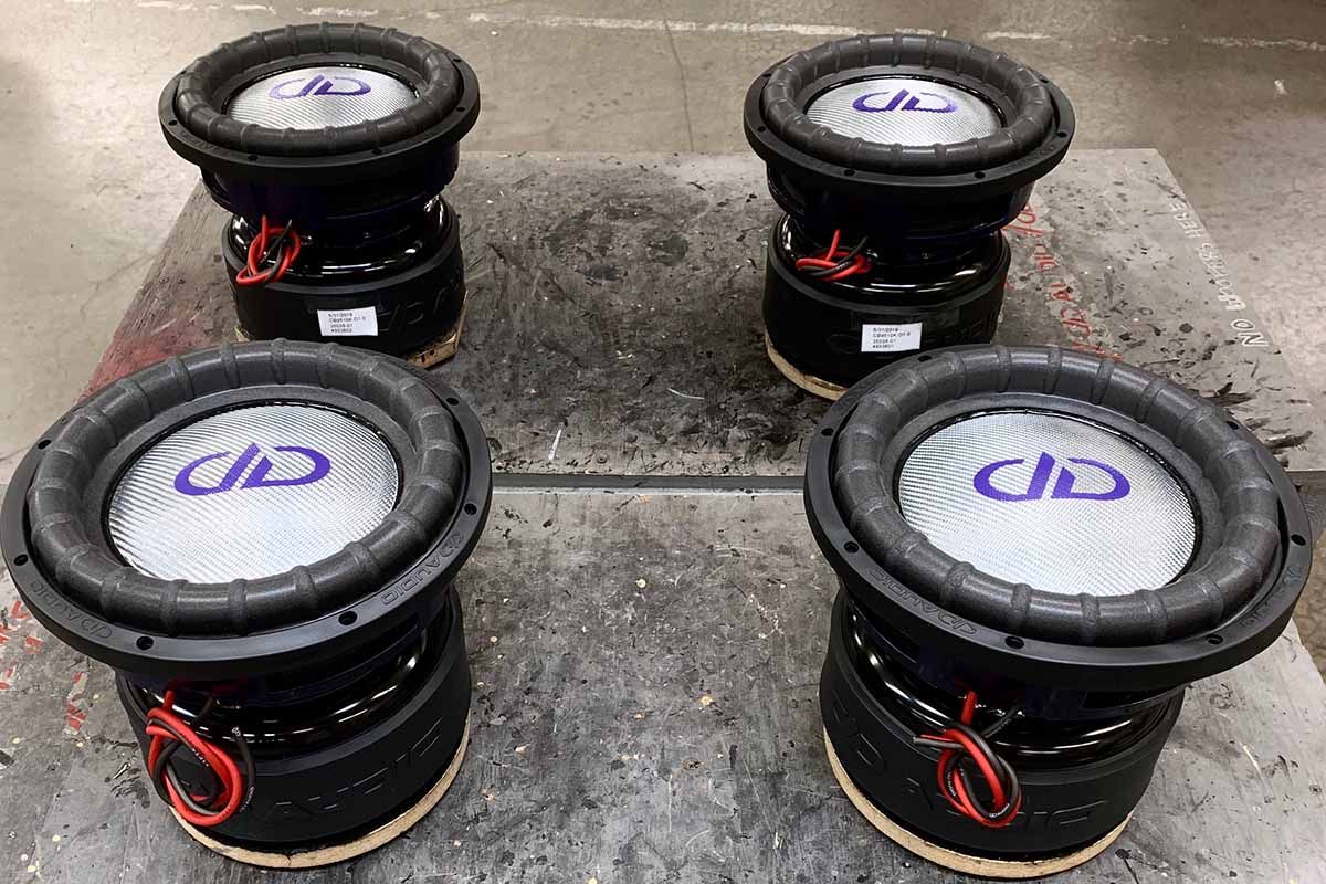 Four USA Made subwoofers with silver dust caps, purple DDA logos
