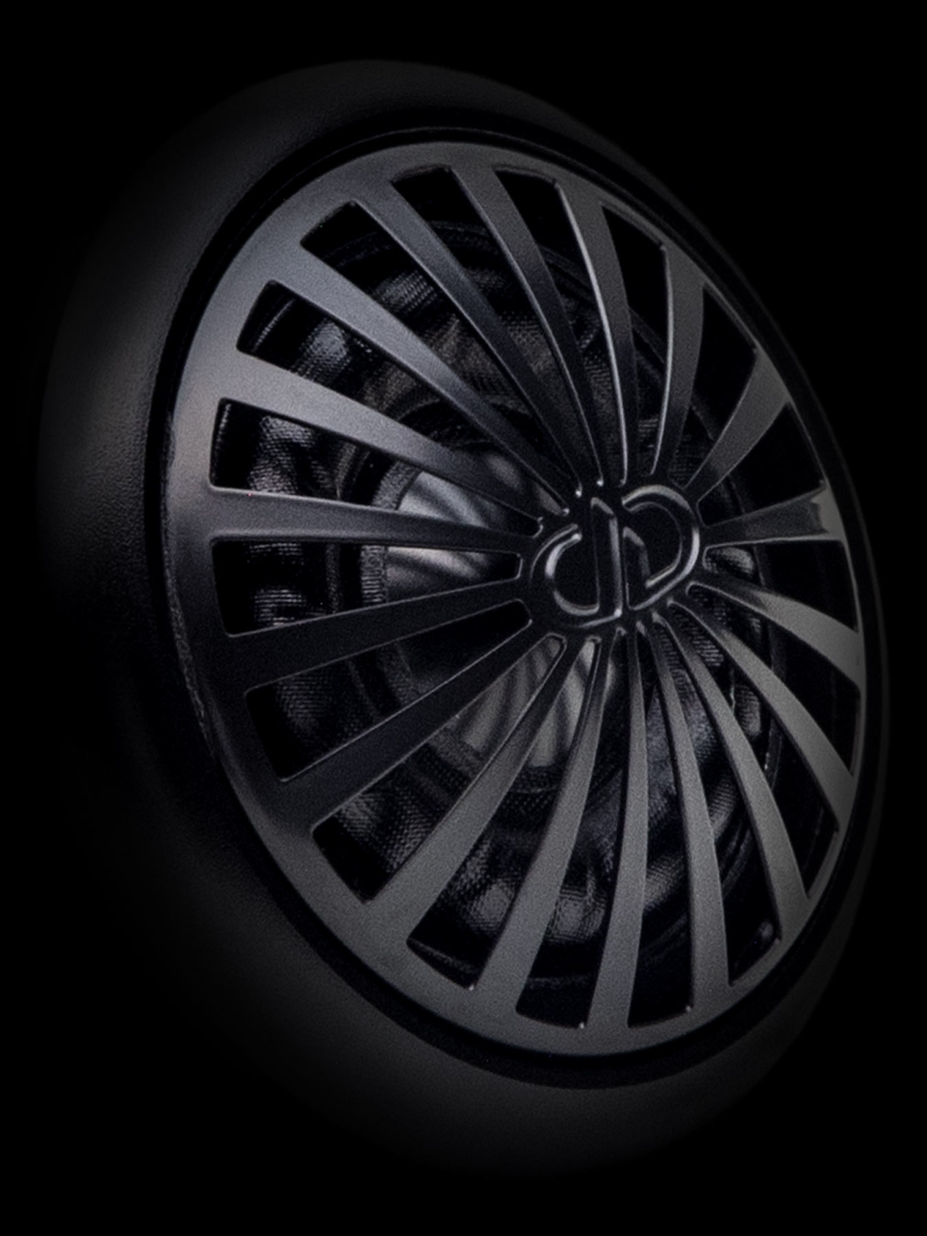 Stylized close-up of tweeter grill with embossed DD logo in center